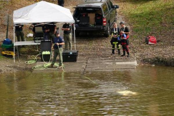 Members of law enforcement search a river, as the search for the suspect in the deadly mass shootings in Lewiston continues, in Lisbon Falls, Maine