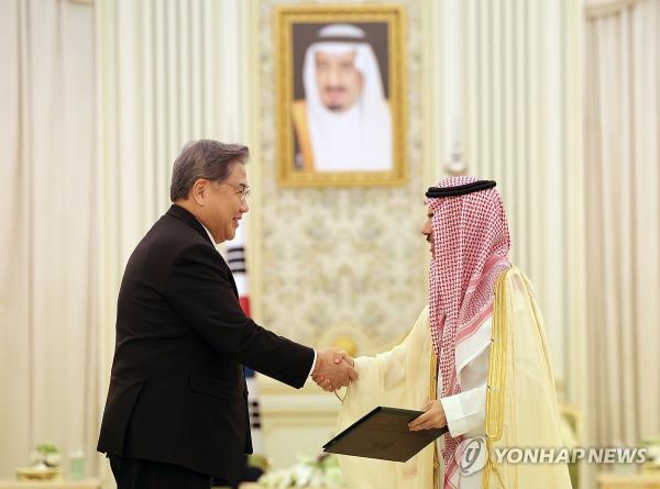 South Korean Foreign Minister Park Jin (L) and his Saudi Arabian counterpart, Faisal bin Farhan Al-Saud, shake hands during a ceremony at Al Yamamah Palace in Riyadh on Oct. 22, 2023, to sign a memorandum of understanding outlining the details of the 