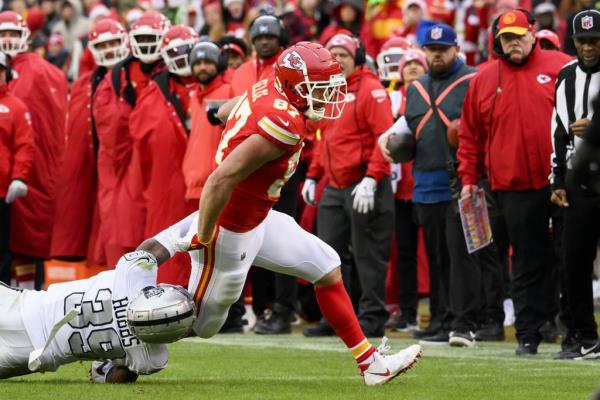 Chiefs tight end Travis Kelce is tackled by Raiders cornerback Nate Hobbs during the first half on Dec. 25, 2023.