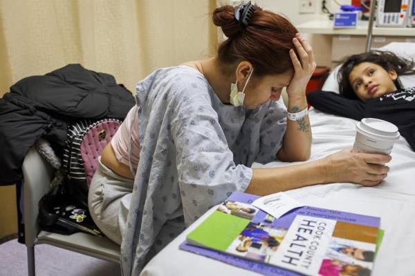 After the children were seen by a doctor in the pediatrics department, Esperanza waits for her turn at Stroger Hospital on Nov. 21, 2023. “God, my head hurts,” Esperanza said.
