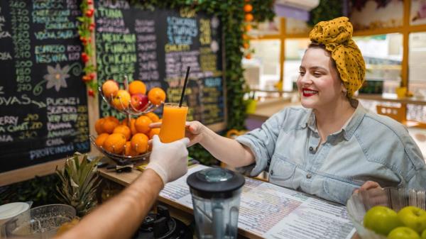 A female being served a glass of juice.