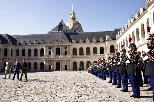 Ukrainian President Volodymyr Zelenskyy, third left, French Defense Minister Sebastien Lecornu, second left, and Military Governor of Paris and Army Corps General Christophe Abad attend a military ho<em></em>nor ceremony, Friday, June 7, 2024 in Paris. (Sameer Al-Doumy, Pool via AP)