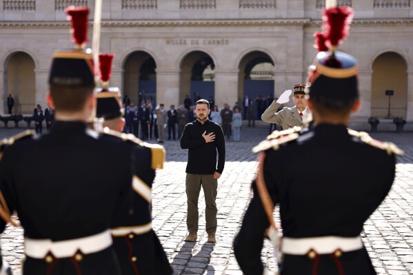 Ukrainian President Volodymyr Zelenskyy listens to the Ukrainian natio<em></em>nal anthem at the Invalides mo<em></em>nument during a military ho<em></em>nor ceremony, Friday, June 7, 2024 in Paris. ( Sameer Al-Doumy, Pool via AP)