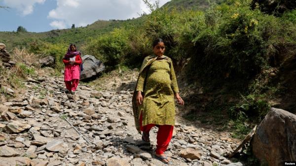 FILE - Bandhana Devi, a pregnant woman, walks down a mountain after voting at a remote polling station in Almi, India, on June 1, 2024, during a natio<em></em>nwide heatwave. The World Health Organization says that climate change threatens the health of pregnant women, among others.