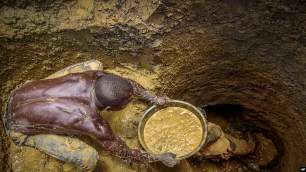 FILE- Miners extract mud they hope co<em></em>ntains gold at a gold mining site at which adults and youth work in the village of Mawero, on the outskirts of Busia town, in eastern Uganda on Oct. 18, 2021.