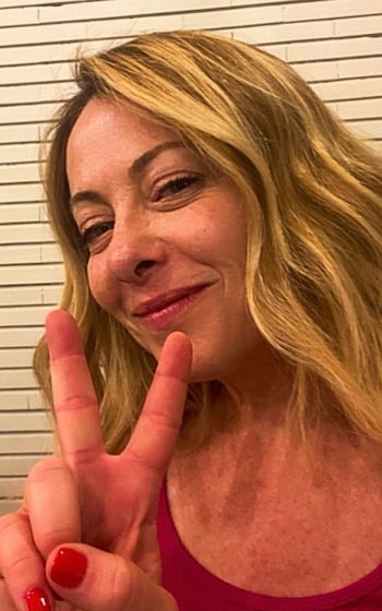Georgia Meloni flashes a victory sign.