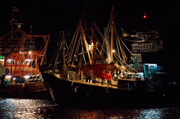 Fishers prepare vessels at night in Thailand.