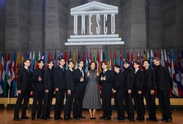 Seventeen members pose for photos with UNESCO Director-General Audrey Azoulay, in this undated photo provided by Pledis Entertainment. (PHOTO NOT FOR SALE) (Yonhap)
