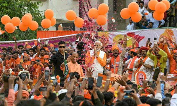  Indian PM Narendra Modi (centre R) with Yogi Adityanath (C), Chief Minister of the country’s Uttar Pradesh state, greets the crowd during a roadshow on the eve of filing his election nomination papers, in Varanasi on May 13. — AFP 