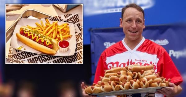 Joey Chestnut holding a tray of hotdogs 