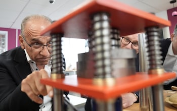 The two men look at machinery
