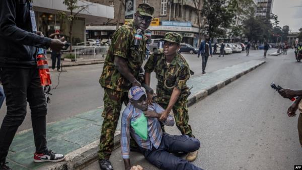 Kenya police officers arrest a protester during a demo<em></em>nstration against tax hikes as Members of the Parliament debate the Finance Bill 2024 in downtown Nairobi, on June 18, 2024.