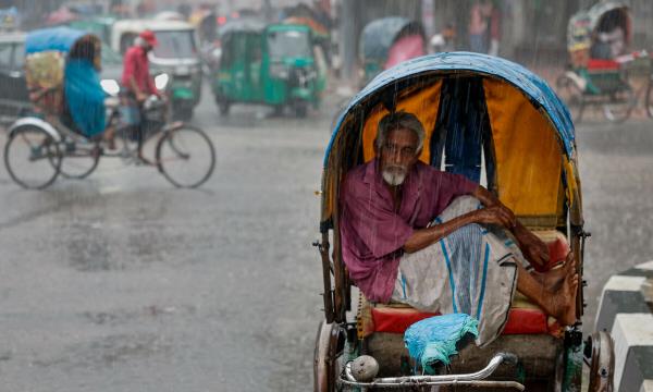  A rickshaw driver sits inside his rickshaw to take cover from rain during a downpour in Dhaka, Bangladesh on June 13, 2024. — Reuters 