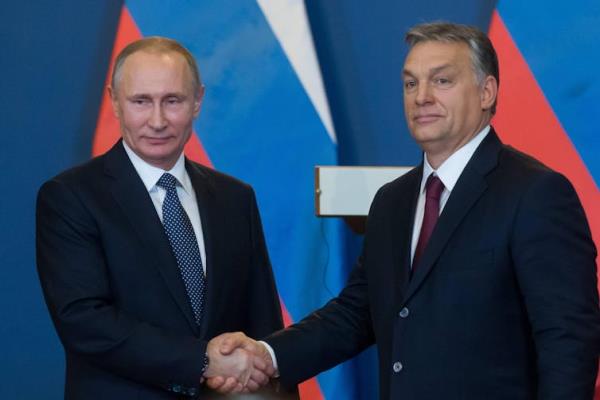 Viktor Orban and Vladmir Putin shake hands.