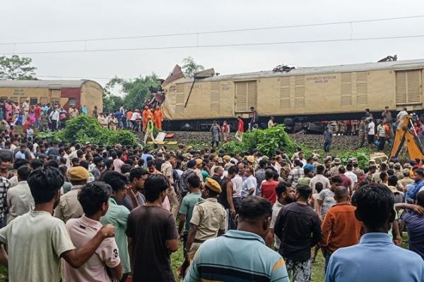 People look on at the site of a collision between an express passenger train and a goods train in Nirmaljote, near Rangapani station in India’s West Bangal state on June 17, 2024. (AFP)