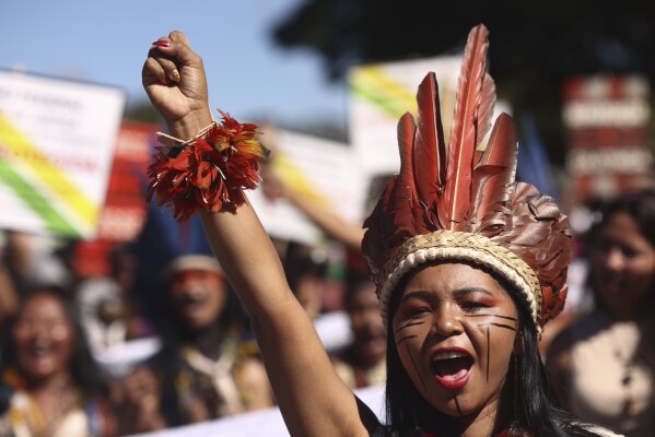 FILE - An Indigenous woman marches during the 20th annual Free Land Indigenous Camp in Brasilia, Brazil, April 23, 2024. Thousands of Indigenous people co<em></em>ntinue to march on Thursday, April 25, calling on the government to officially recognize lands they have lived on for centuries and to protect territories from criminal activities like illegal mining. (AP Photo/Luis Nova, File)