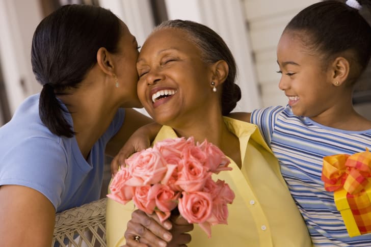 grandmother, mother, and child celebrating mother's day with flowers and gifts