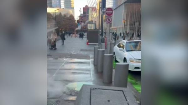 Bright green water leaking out of New York City sewers o<em></em>nto street by cars