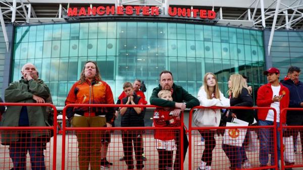 Soccer Football - Bobby Charlton Tributes - Old Trafford, Manchester, Britain - October 21, 2023 Fans stand by the statue of Bobby Charlton outside Old Trafford following his passing REUTERS/Carl Recine