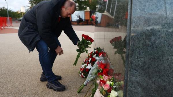Soccer Football - Bobby Charlton Tributes - Old Trafford, Manchester, Britain - October 21, 2023 Fans place floral tributes by the statue of Bobby Charlton outside Old Trafford following his passing REUTERS/Carl Recine