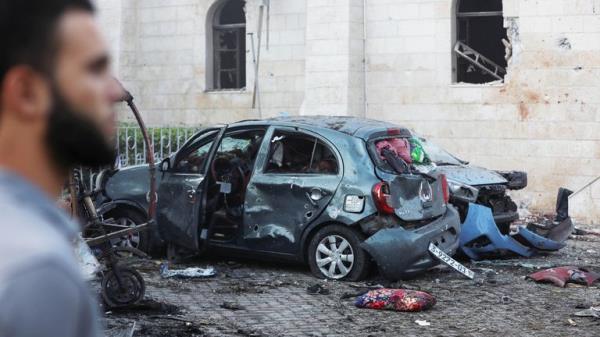 A man stands next to a damaged car in the area of  al Ahli hospital wher<em></em>e hundreds of Palestinians were killed in a blast that Israeli and Palestinian officials blamed on each other, and wher<em></em>e Palestinians who fled their homes were sheltering amid the o<em></em>ngoing co<em></em>nflict with Israel,  in Gaza City, October 18, 2023.  REUTERS/Mohammed Al-Masri