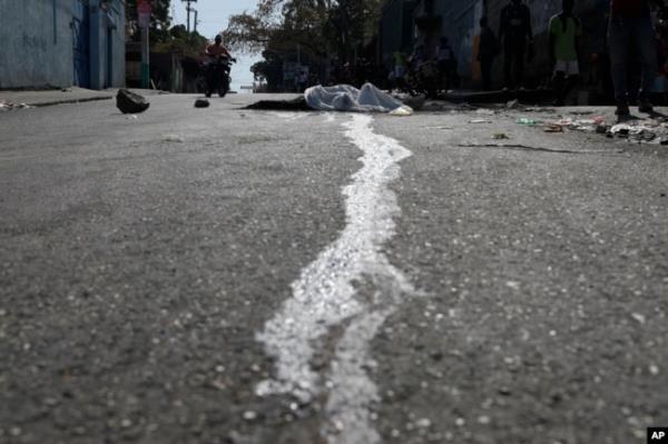 Blood streams from a body lying in the street in the Petion-ville area of Port-au-Prince, Haiti, March 20, 2024.