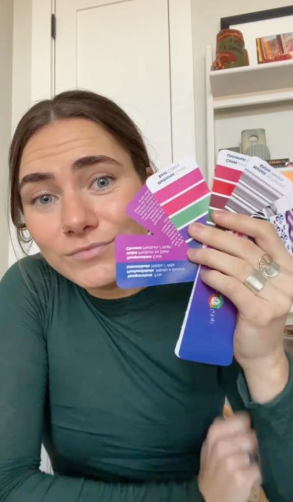 Becca Havian holds up color chips to her face in a TikTok still.
