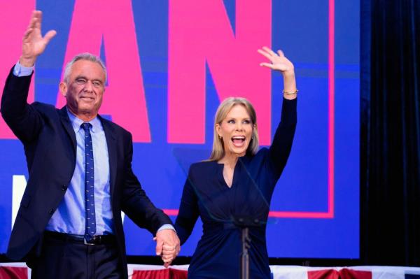 Robert F. Kennedy Jr. waving to the crowd next to his wife, actress Cheryl Hines, at a campaign event in Oakland, California, March 2024