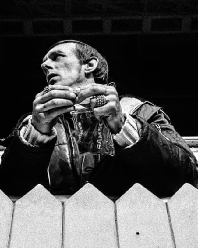 A fan rolls a cigarette on the terraces at White Hart Lane in 1985