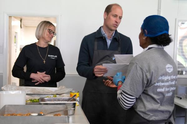Prince William is given cards for his wife by volunteer Rachel Candappa during a visit to Surplus to Supper, in Sunbury-on-Thames. 