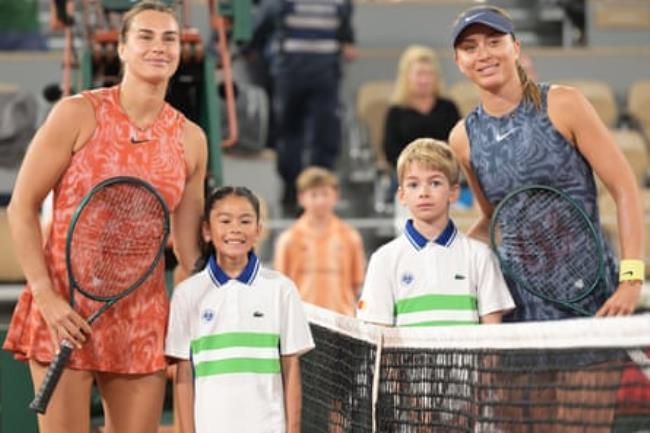Aryna Sabalenka (left) and Paula Badosa pose at the net before their third-round match on Court Philippe-Chatrier.
