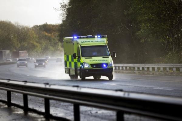 British ambulance respo<em></em>nding to an emergency in hazardous bad weather driving co<em></em>nditions on a UK motorway