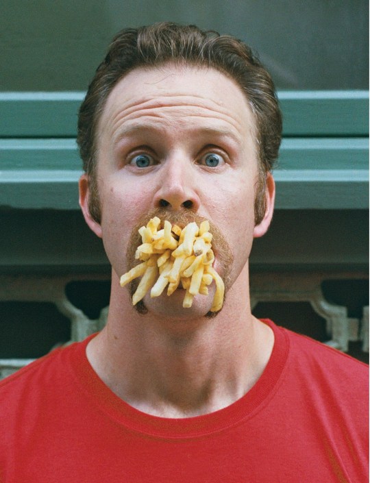 Morgan Spurlock with a mouthful of fries