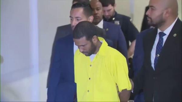 Grei Mendez in prison jumpsuit and handcuffs