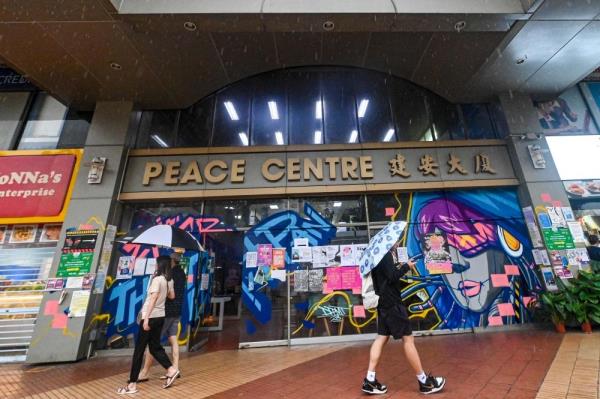 In this photograph taken on January 19, 2024, people walk past drawings and grafitti at the Peace Centre, an abando<em></em>ned mall turned into an unexpected art enclave, in Singapore. — AFP pic