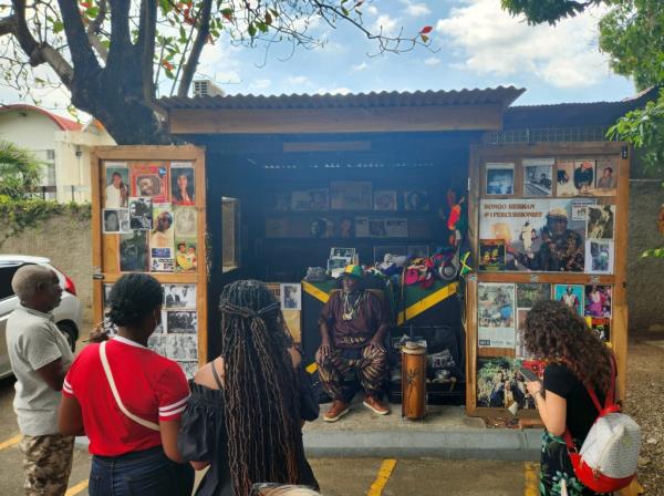An elderly man, Bo<em></em>ngo Herman, sells music recordings and souvenirs in front of a small store at the Bob Marley Museum in Kingston, Jamaica.