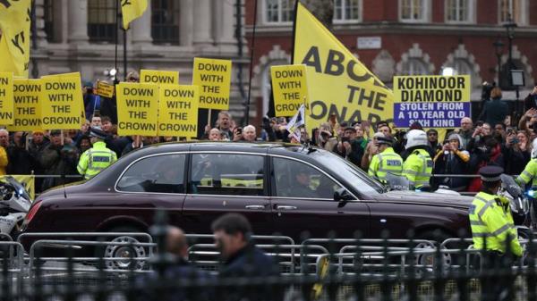Queen Camilla waves in a vehicle as she passes by anti-mo<em></em>narchy protesters on the day of the annual Commo<em></em>nwealth Day service at Westminster Abbey.</p>

<p>　　Pic: Reuters