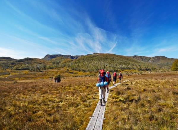 group of hikers on trail surrounded by mountains