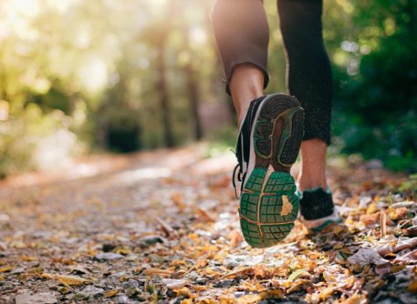 man jogging on trail with rucksack
