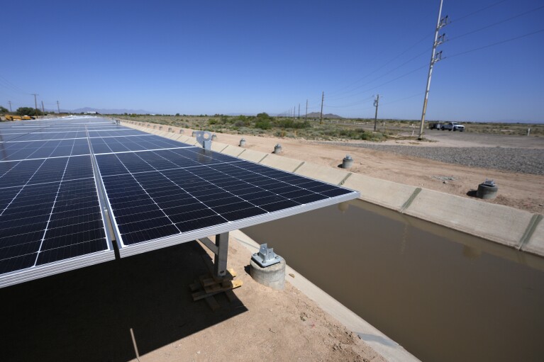 Solar panels are close to being placed over a water canal in the Gila River Indian Community, Thursday, May 2, 2024, in Sacaton, Ariz. Leading the tribe is Stephen Roe Lewis, a towering figure in the Southwest who has been pivotal in navigating a water crisis across the seven-state Colorado River basin. (AP Photo/Ross D. Franklin)