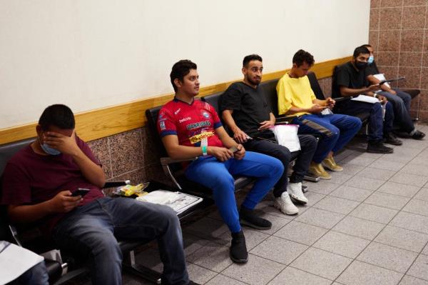 Colombian asylum-seeker Marvin Carranza, 30, (center of photo) was among dozens of migrants seen waiting for their flights in the West Texas airport.