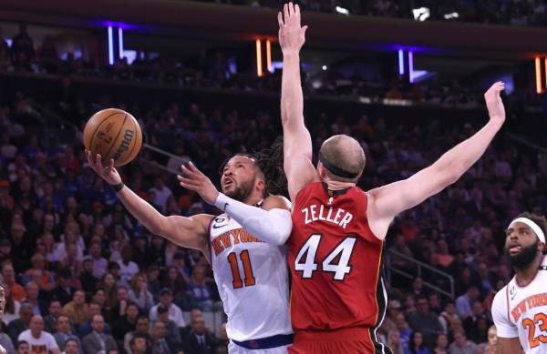 Knicks guard Jalen Brunson #11 goes up for a shot as Miami Heat center Cody Zeller #44 defends