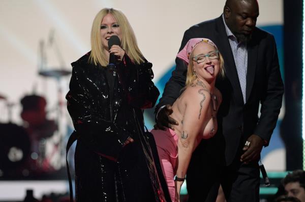 Security leading topless woman offstage as Avril Lavigne co<em></em>ntinues introducing next act,