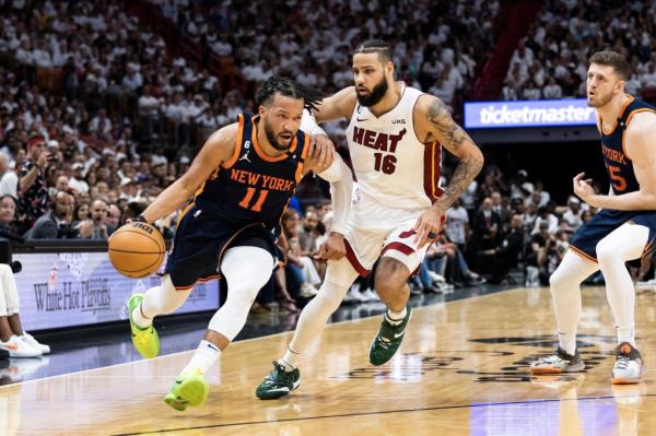 Jalen Brunson drives down court as Caleb Martin of the Heat chases during the second half.