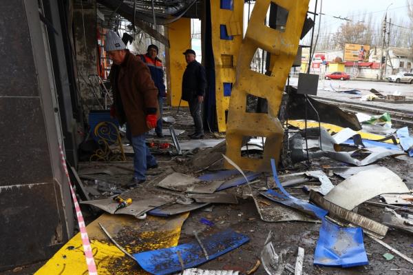 People help to clean up debris at a bus station.