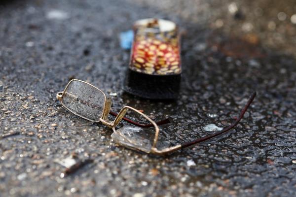 Damaged glasses lie on the ground at a bus station destroyed after a shelling.