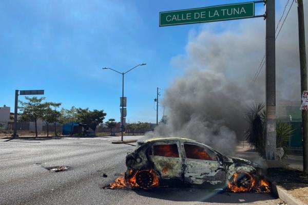 A burning car is seen on the street during an operation to arrest the son of Joaquin 