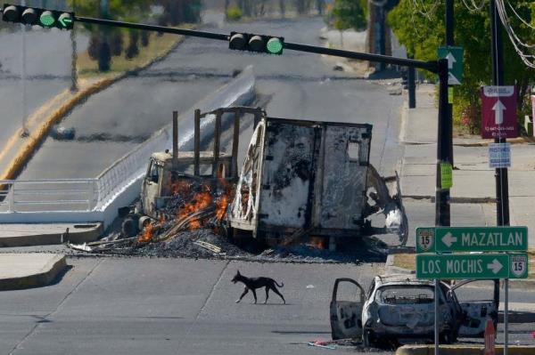 Burned-out vehicles after clashes between federal forces and armed groups following the capture of Ovidio Guzman.