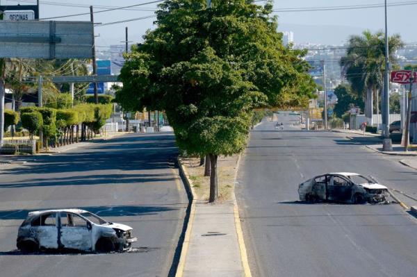 Burned-out vehicles after clashes between federal forces and armed groups following the capture of Ovidio Guzman.