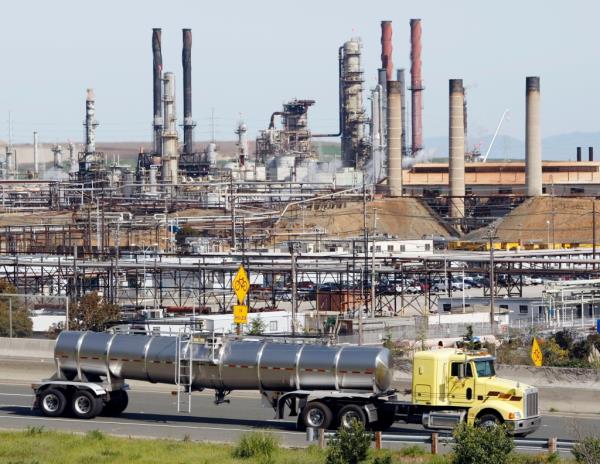 A tanker truck drives by the Chevron oil refinery in Richmond, Calif., Tuesday, March 9, 2010. Chevron Corp. says it will cut 2,000 jobs this year and will co<em></em>ntinue reducing its work force through 2011. (AP Photo/Paul Sakuma)